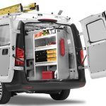 A white van with its doors open and shelves in the back.