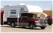 A red truck with a trailer attached to it.
