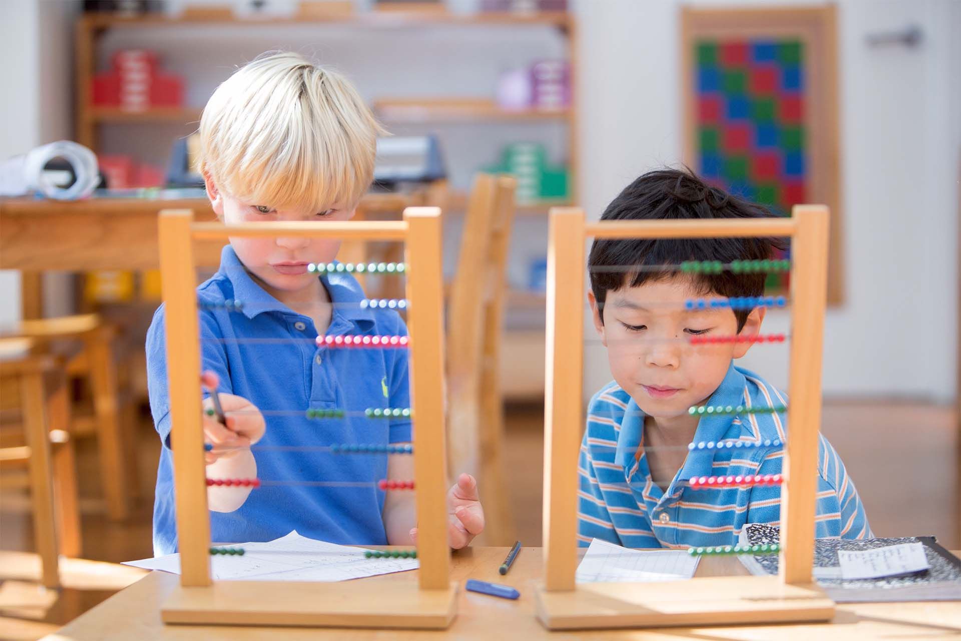 Montessori children are working with an abacus in a classroom.