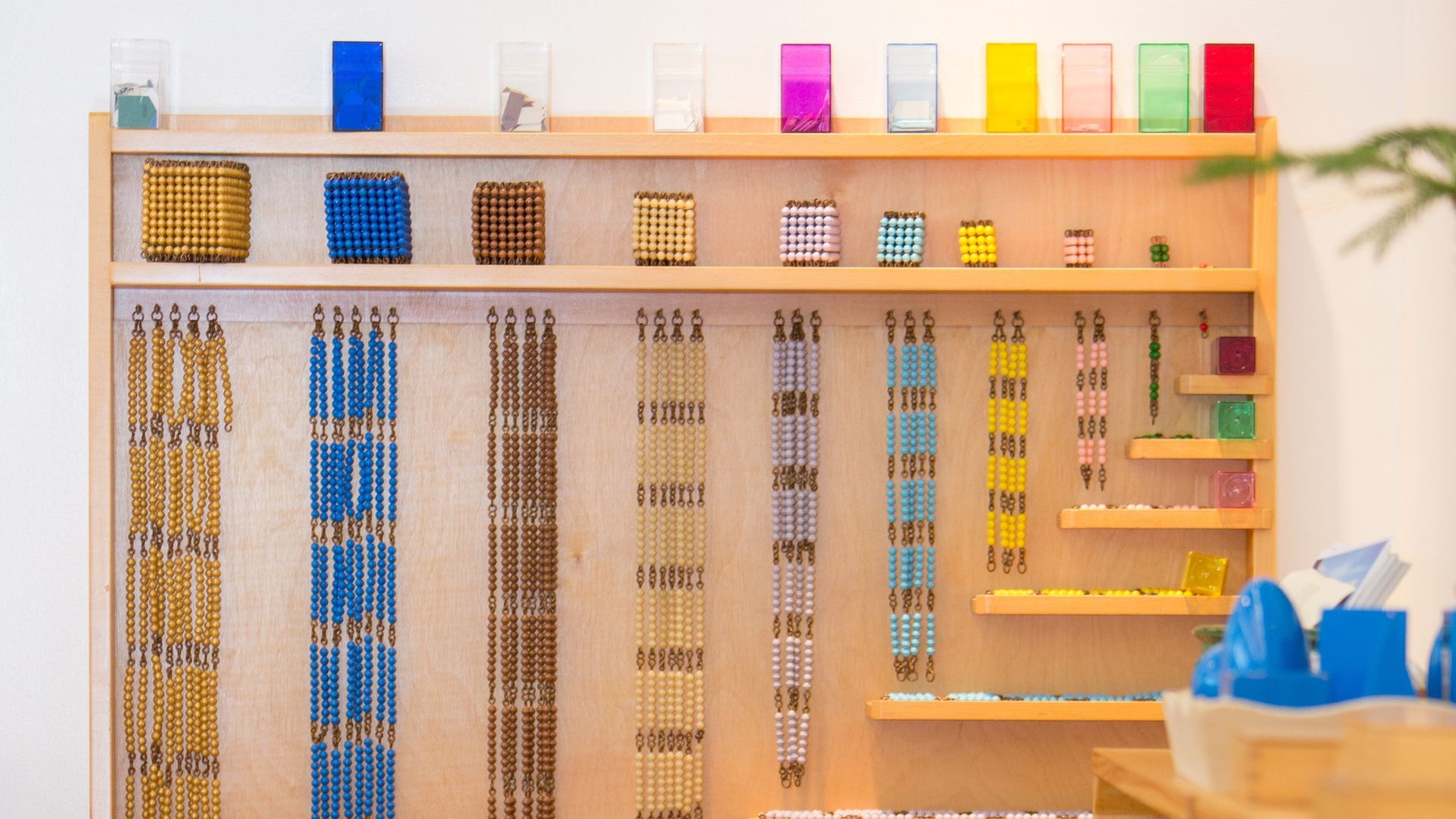 There are many different colored beads hanging on the wall.