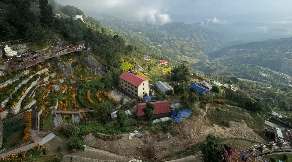 An aerial view of a valley with a house in the middle of it.