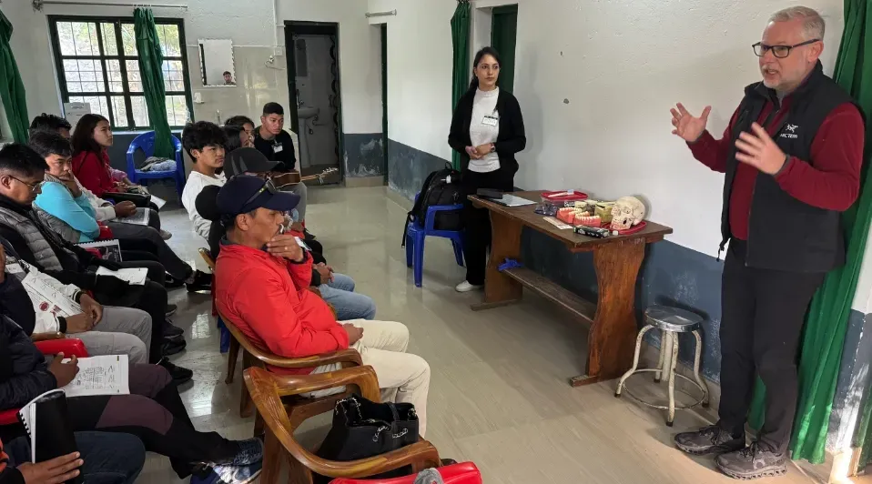 A man is giving a presentation to a group of people sitting in chairs.