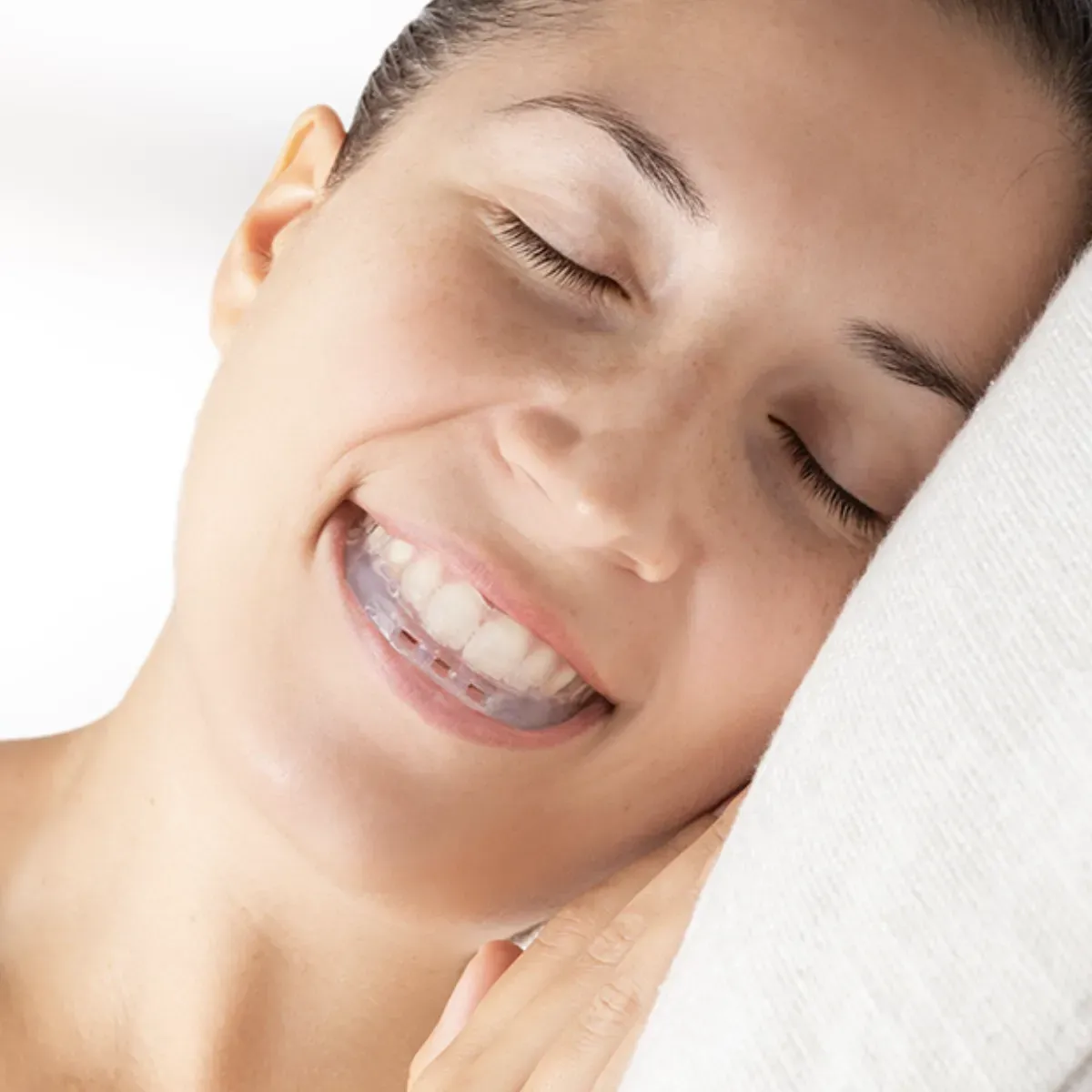 woman peacefully sleeping with an orthodontic sleep apnea appliance in her mouth