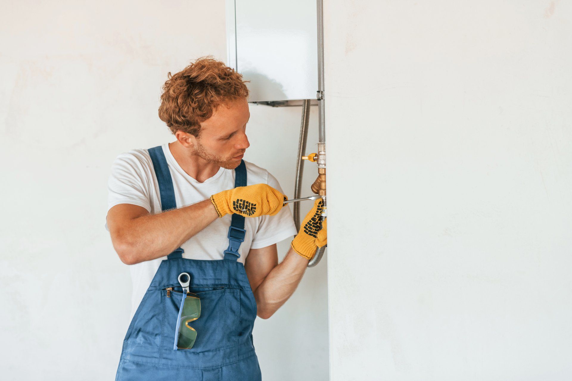 repair person fixing a pipe using a screwdriver