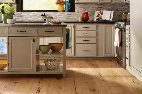 Bright kitchen with island, wood floor, and bowls on the counter under a window