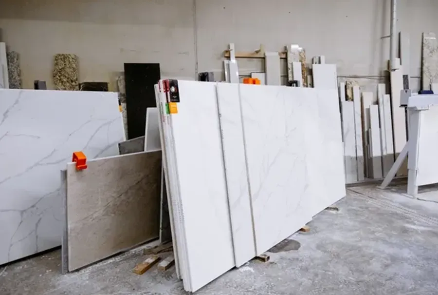 Large white marble slabs displayed upright in a warehouse showroom