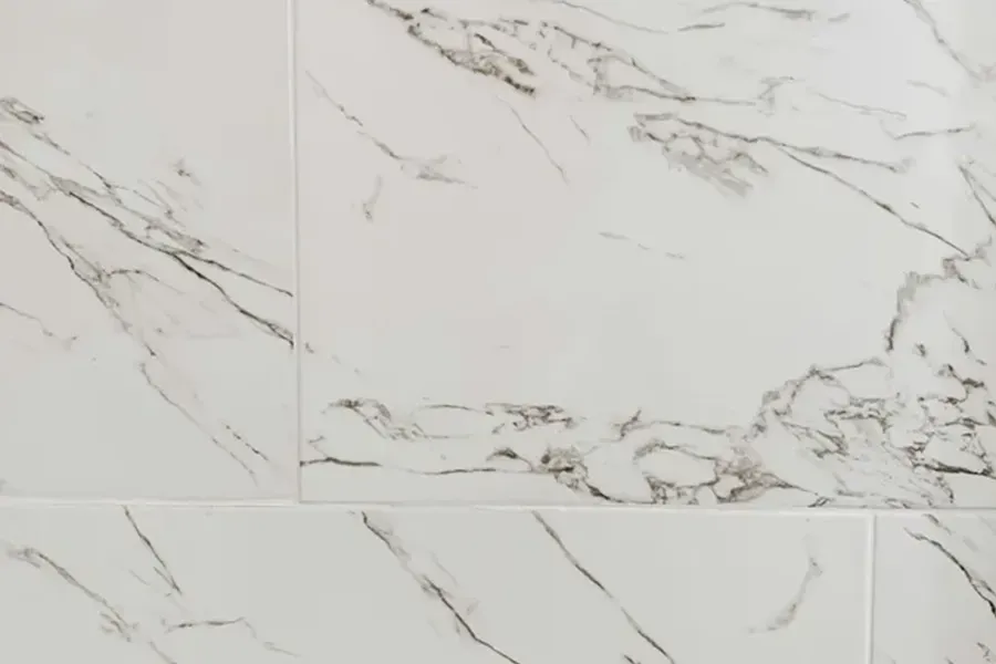White marble tile pattern with gray veining and rectangular tile seams