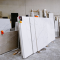 Stacked white marble slabs in a workshop or stone warehouse