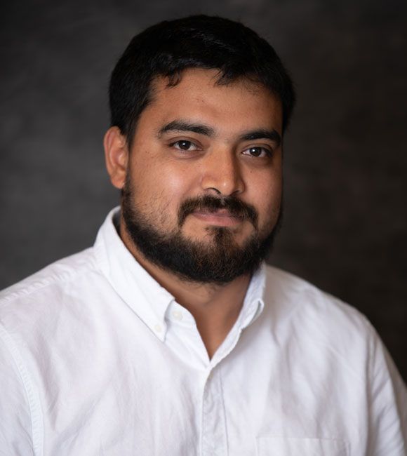 Portrait of a man in a white shirt against a dark studio background