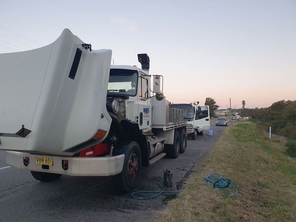 A White Truck With The Hood Up Is Parked On The Side Of The Road  — Newcastle Truck Repairs in Thornton, NSW