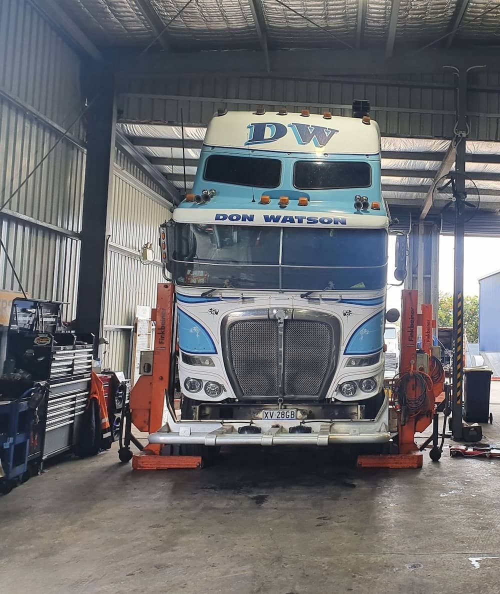 A Truck Is Sitting On A Lift In A Garage  — Newcastle Truck Repairs in Thornton, NSW