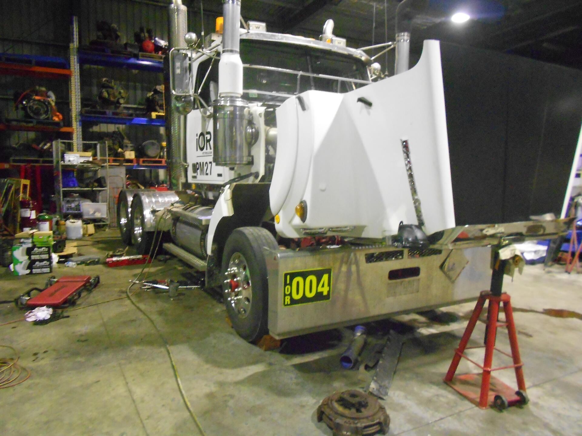 A Man Is Working On The Back Of A Semi Truck — Newcastle Truck Repairs in Beresfield, NSW