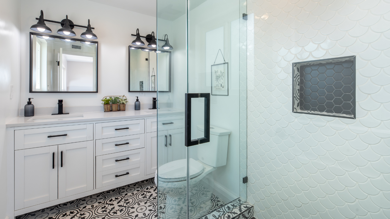 Modern bathroom with white vanity, black accents, and glass shower.
