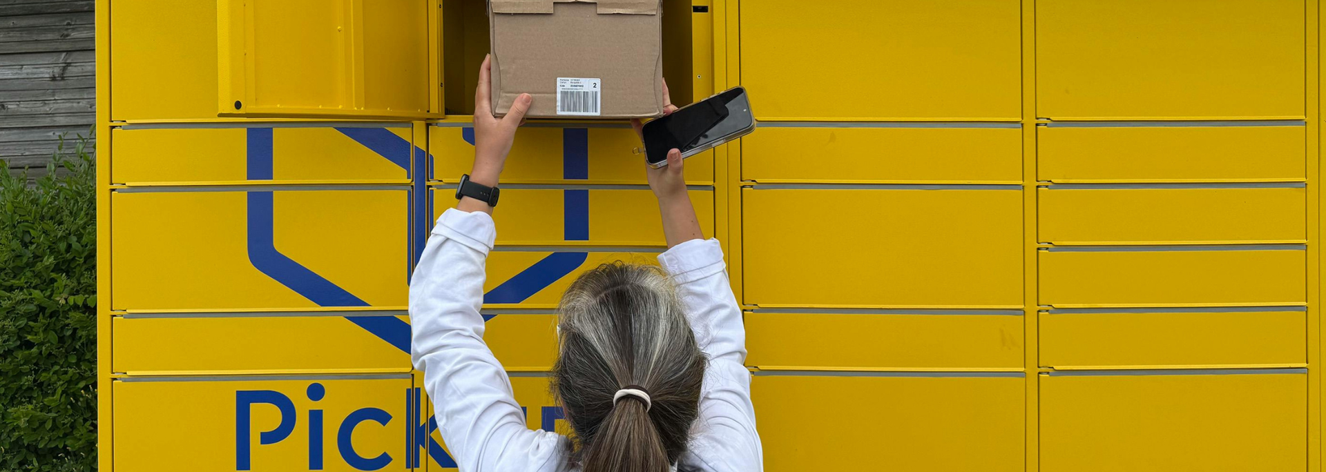 Picture of person getting a parcel from a parcel locker. 