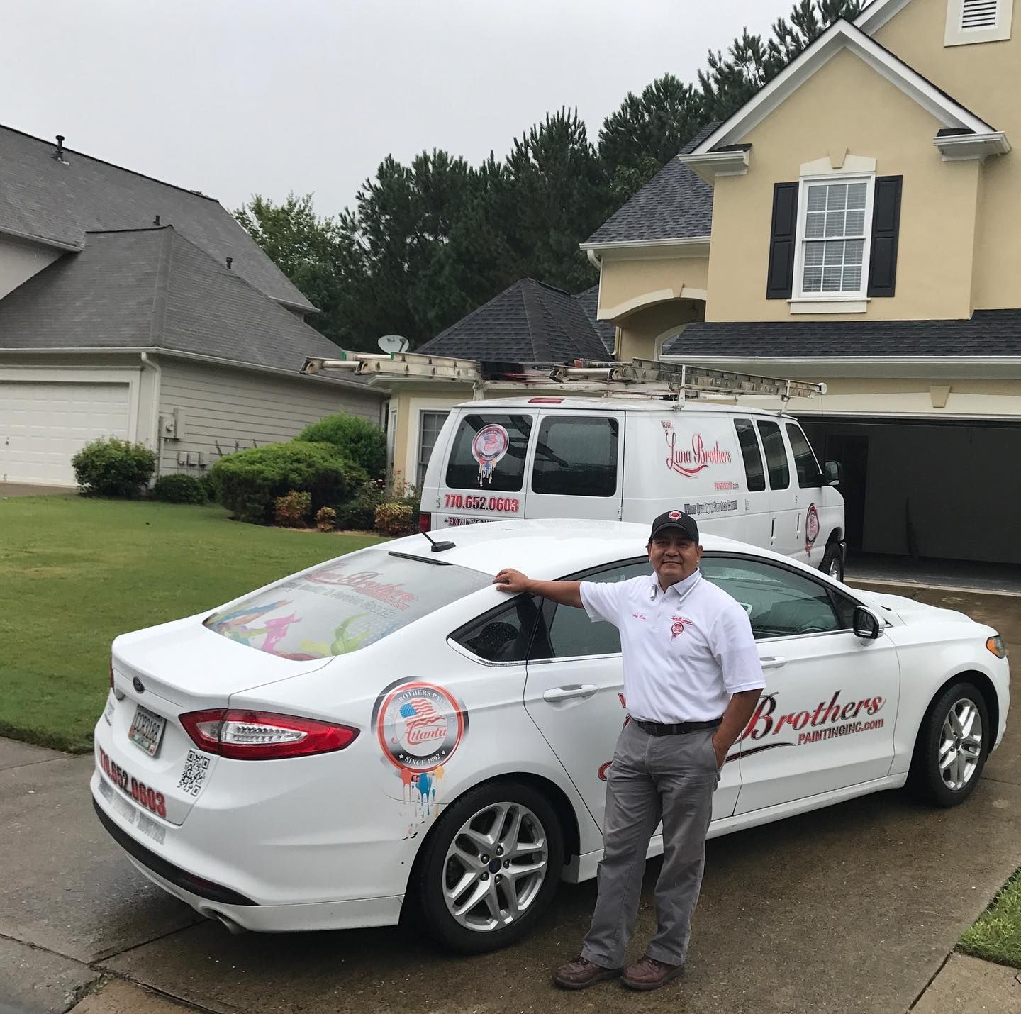 A man standing next to a white car that says brothers