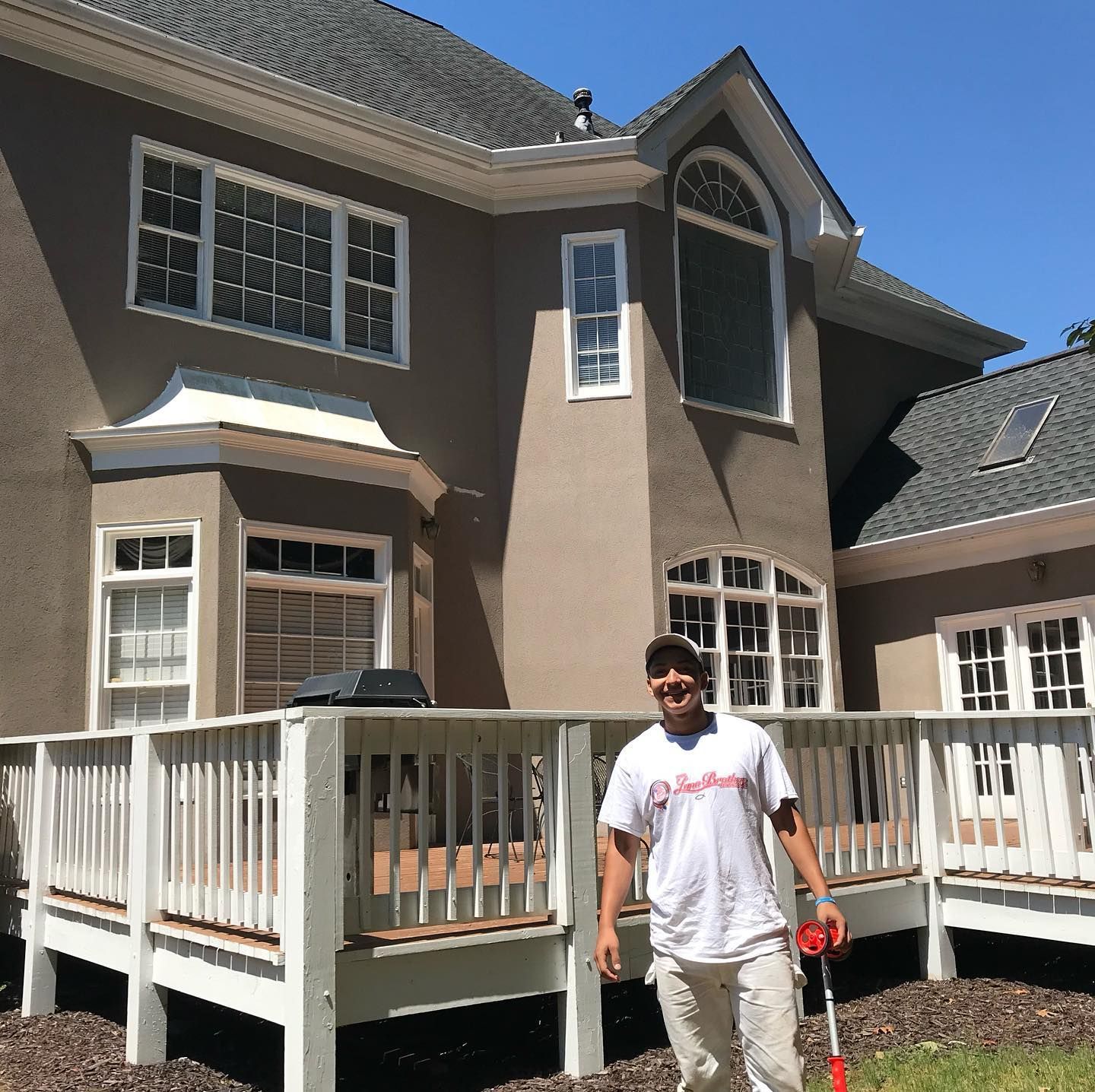A man is standing in front of a large house