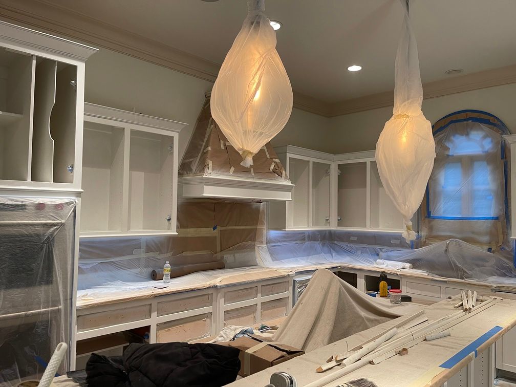 A kitchen is being remodeled with white cabinets and counter tops.