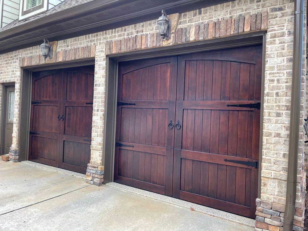 A row of wooden garage doors on a brick building.