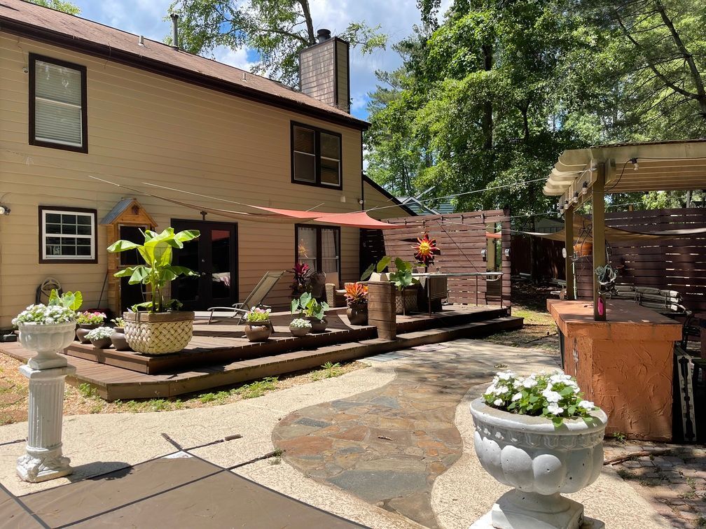 The backyard of a house with a large deck and umbrellas.