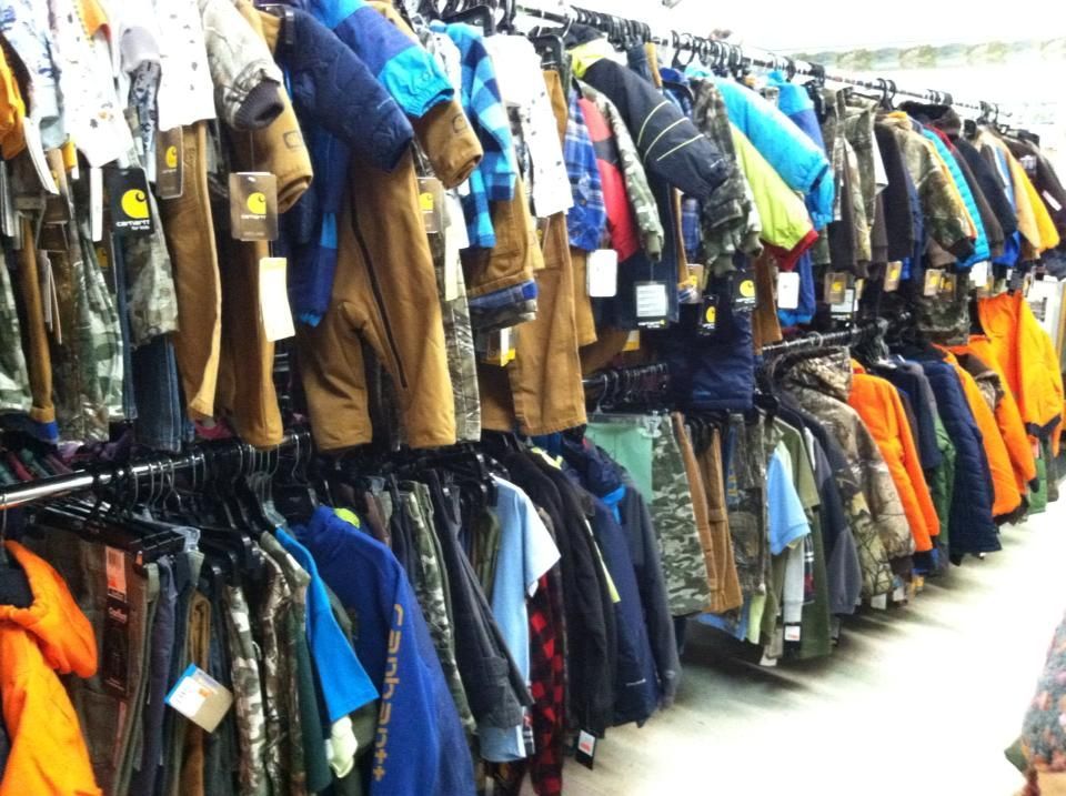 A row of clothes hanging on racks in a store