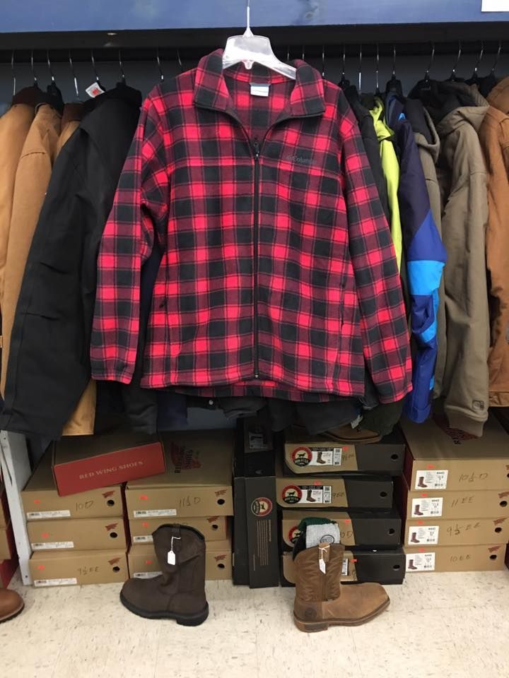 A red and black plaid jacket is hanging on a rack