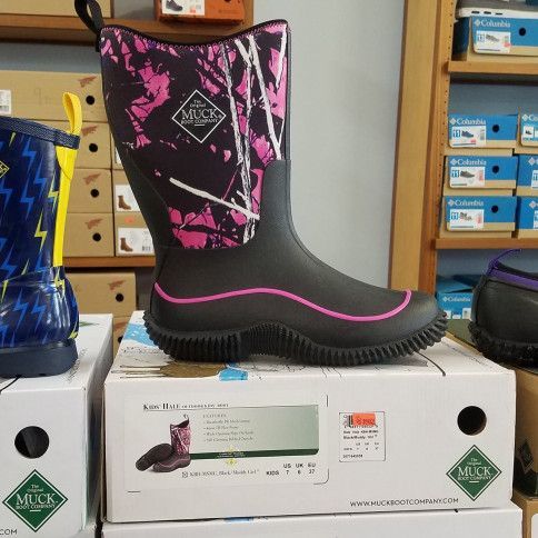 A pair of muck boots are sitting on top of a stack of boxes