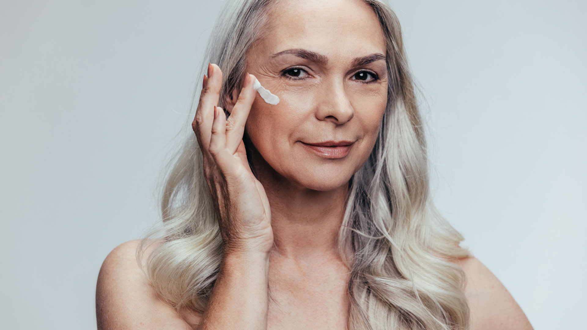 Smiling woman with short gray hair touching face, with skincare close-ups highlighting wrinkles and skin texture