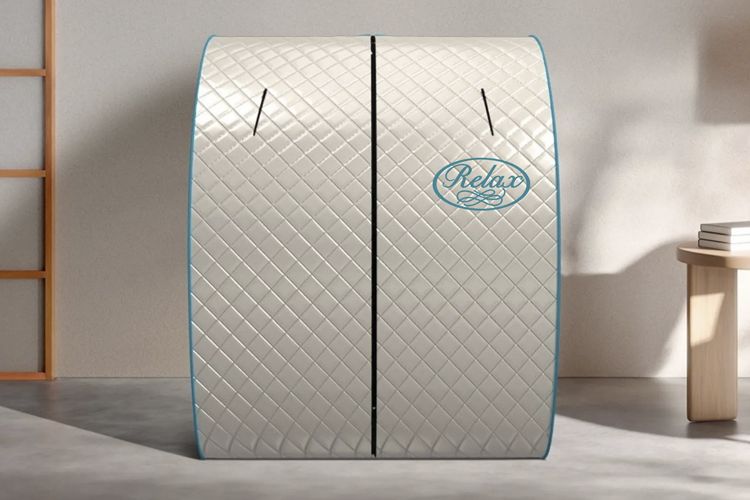 Two white quilted mattresses with blue trim and logo, standing upright in a bright room