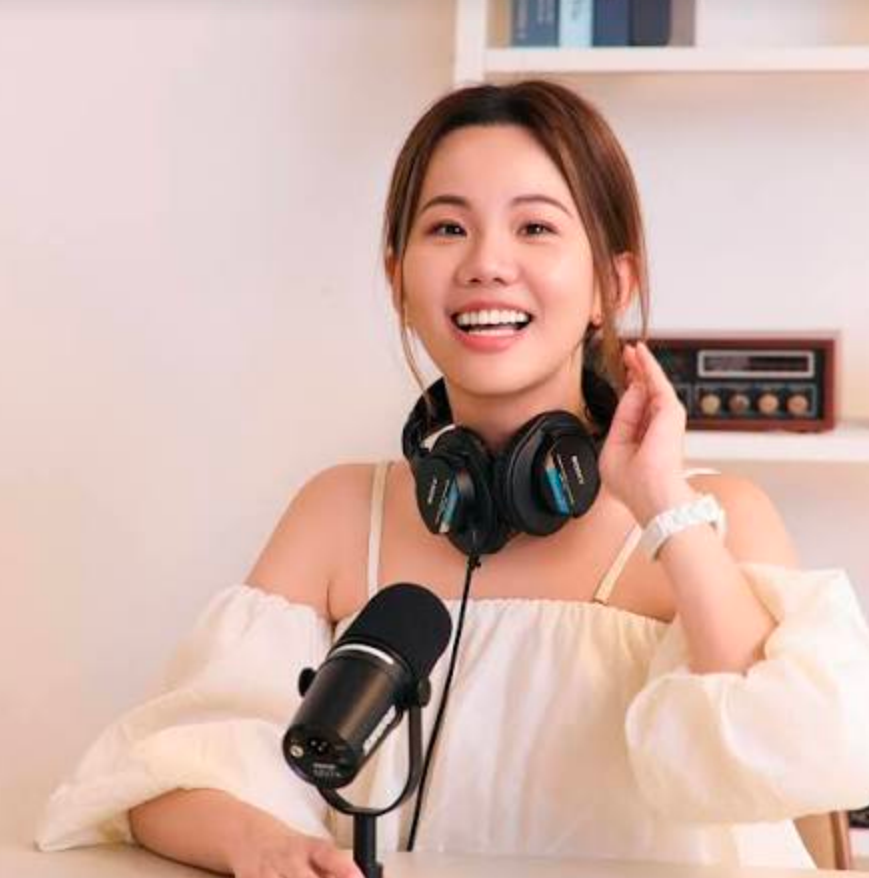 一位戴著墨鏡的女士坐在水體前的桌子旁