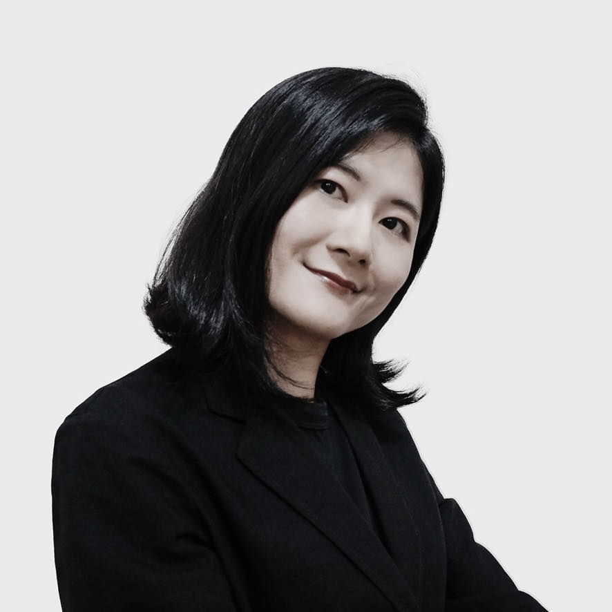 黑白照片中，一名身穿條紋襯衫的女子正在微笑。