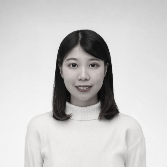 一張黑白照片中，一位穿著西裝和白襯衫的女人微笑著。