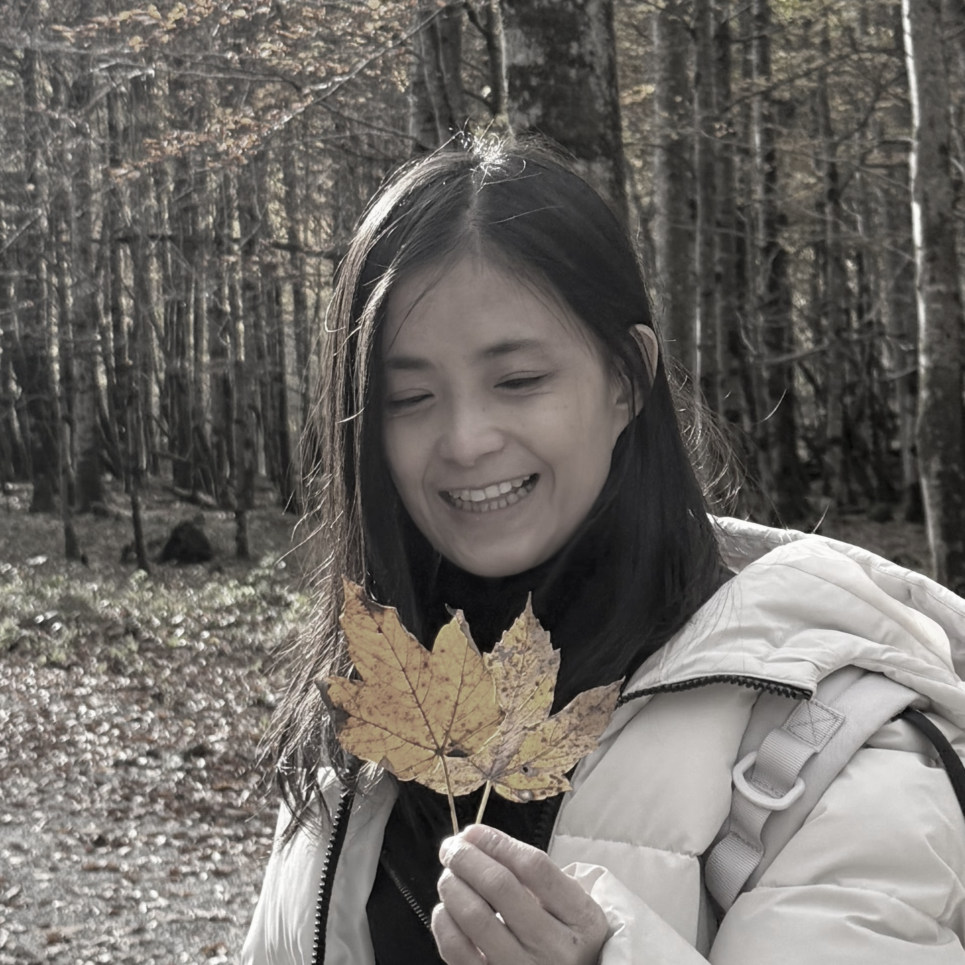一張黑白照片，照片中一個穿著西裝的女人圍著一圈微笑。