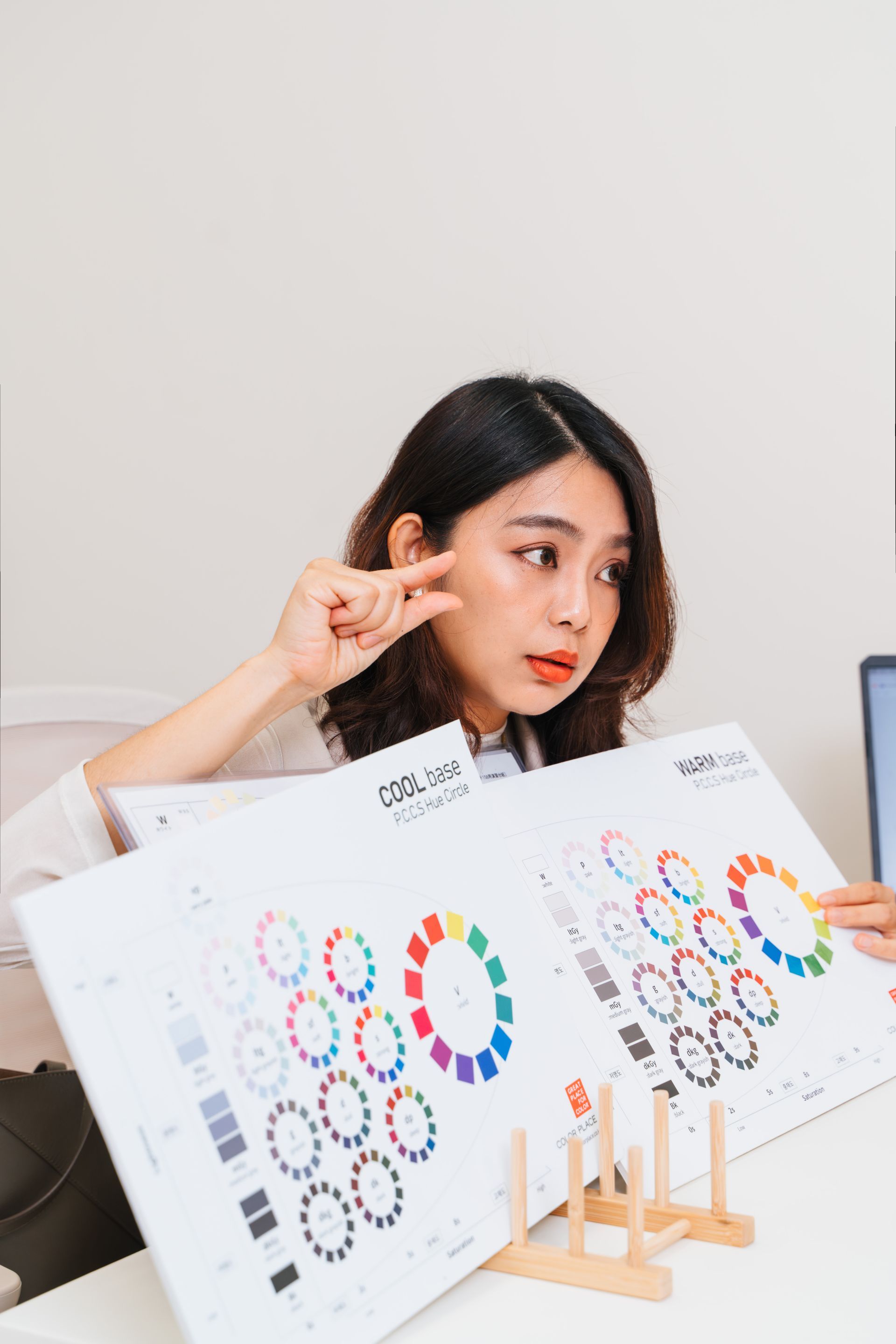 一位女士坐在辦公桌前,手裡拿著一個調色盤。