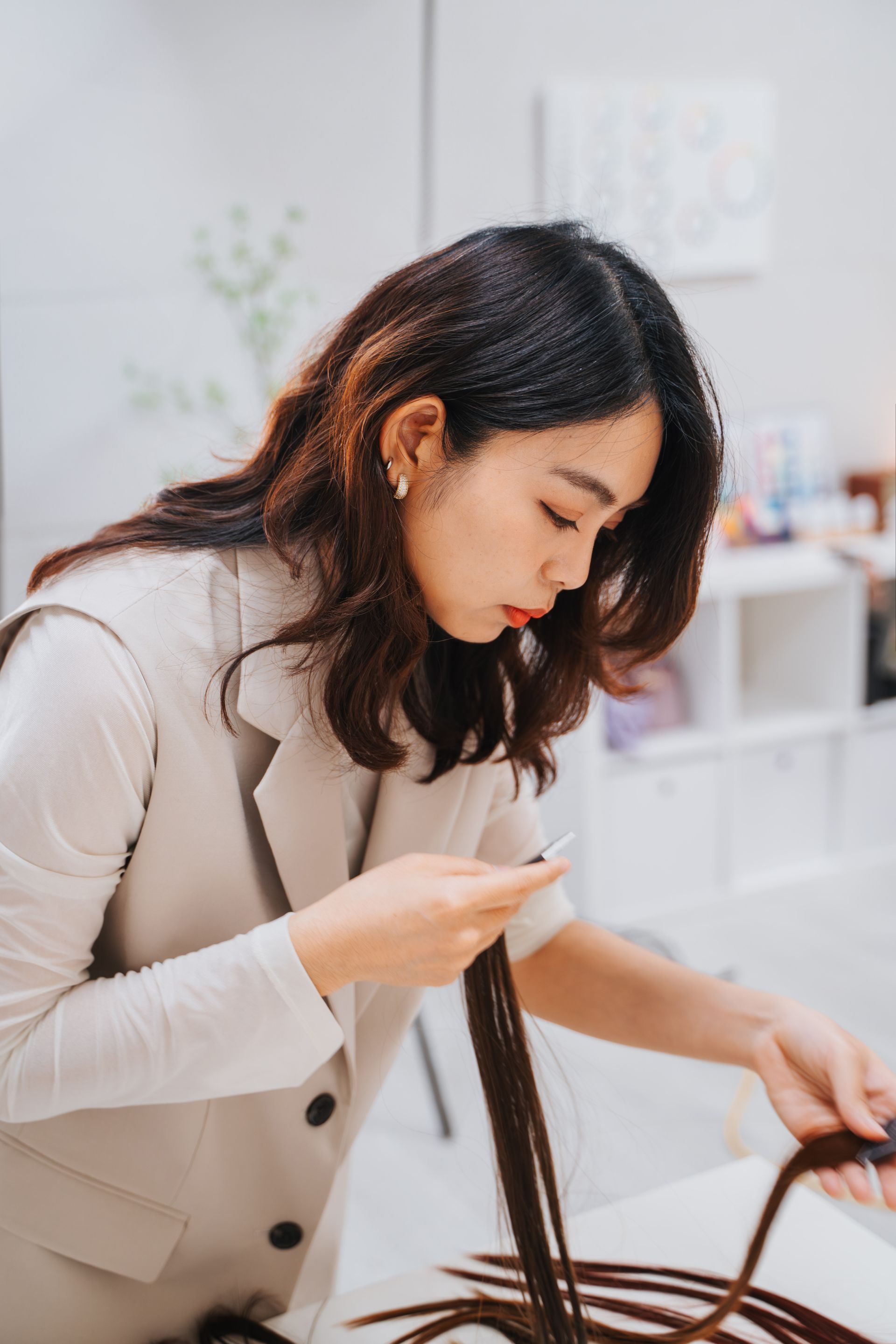 一個女人坐在桌邊,手裡拿著一根頭髮。