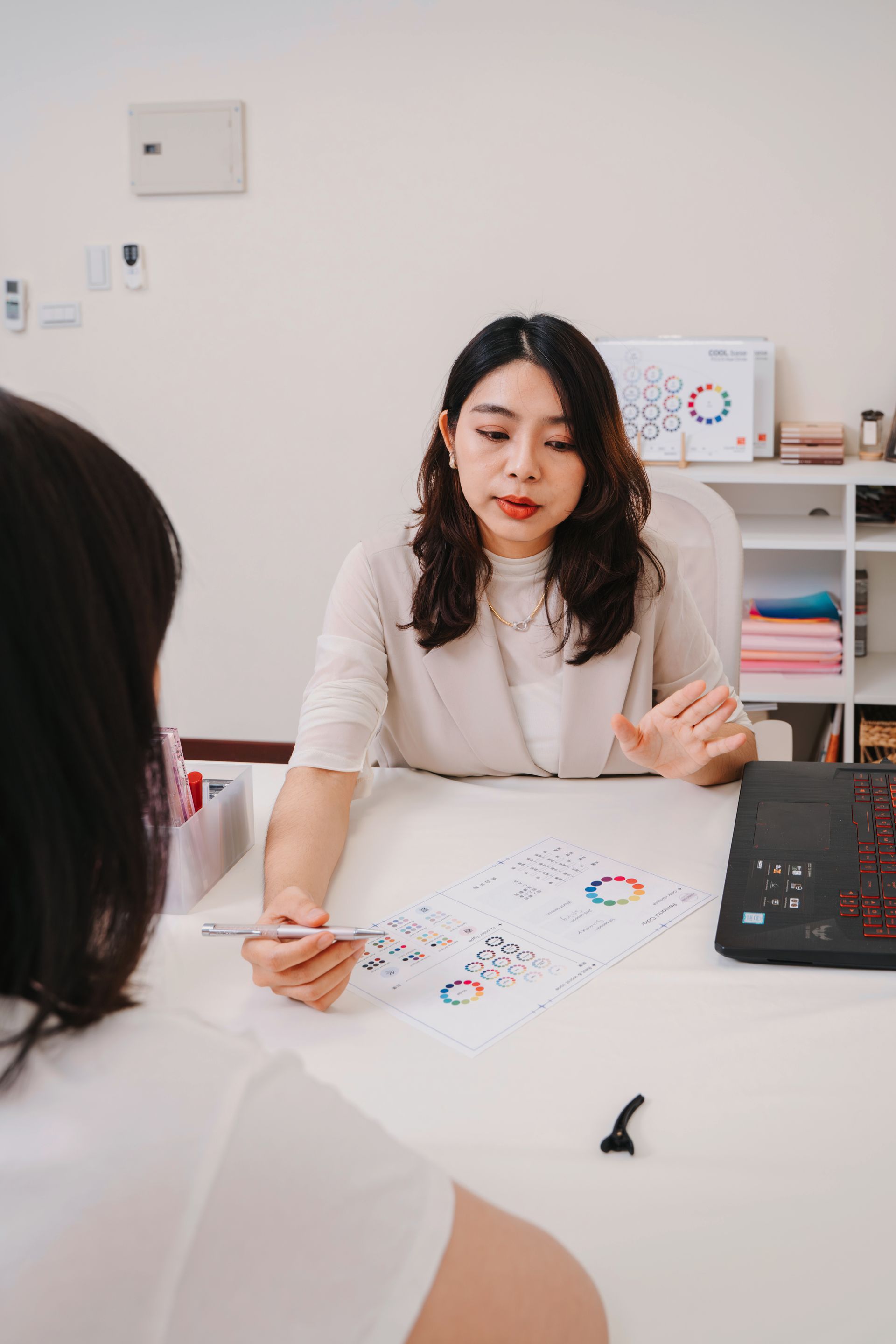 一個女人坐在桌旁與另一個女人交談。