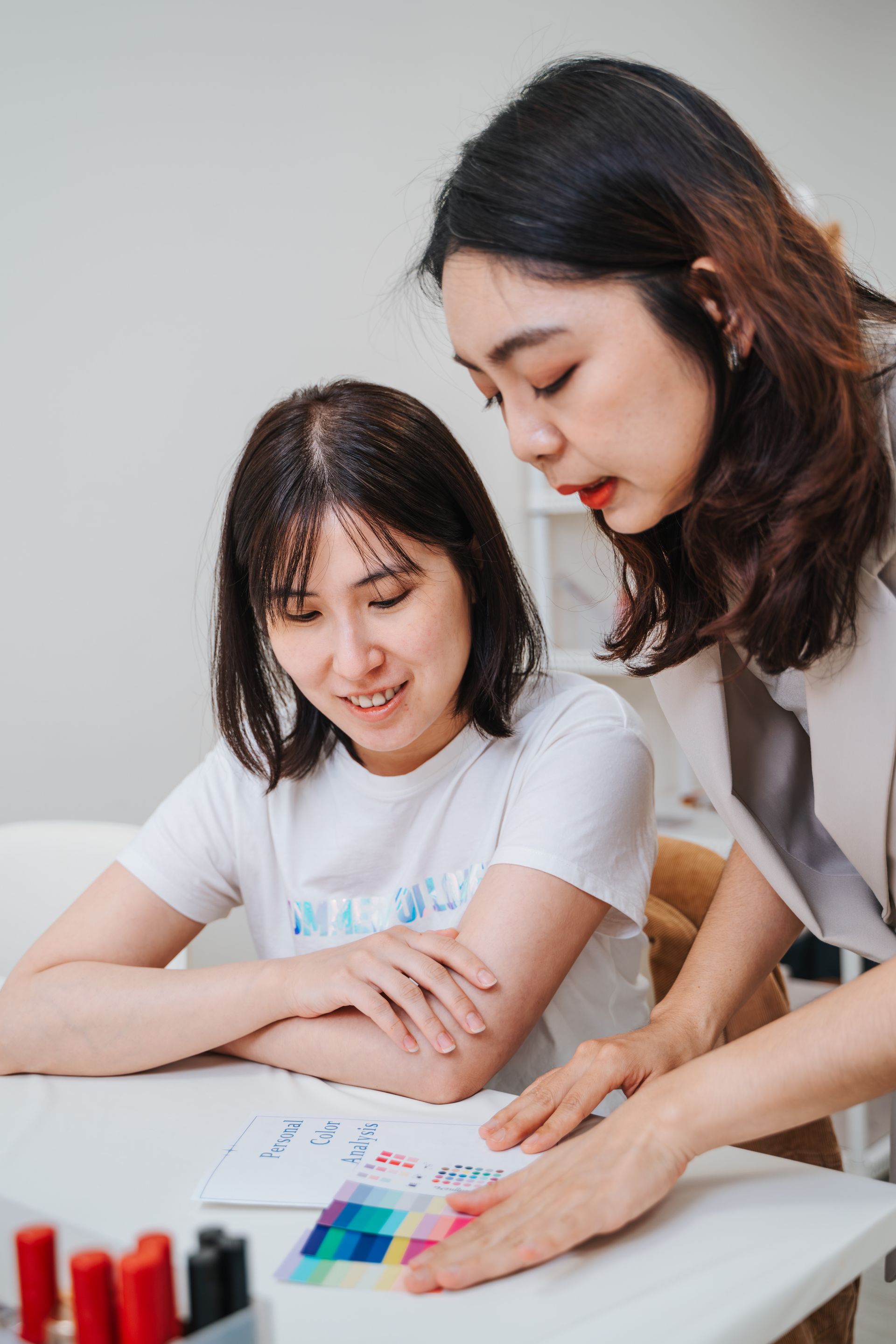 兩個女人坐在桌子旁看著一張紙。