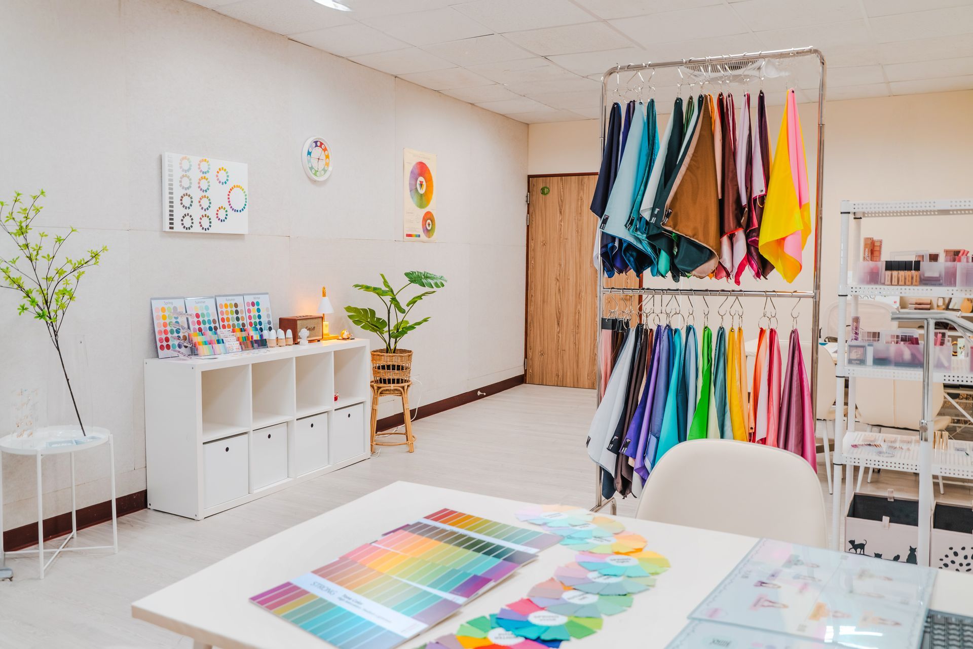 房間裡有桌子、椅子、架子和衣服展示架。