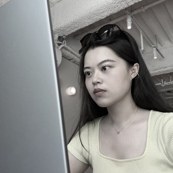 黑白照片中，一名身穿條紋襯衫的女子正在微笑。