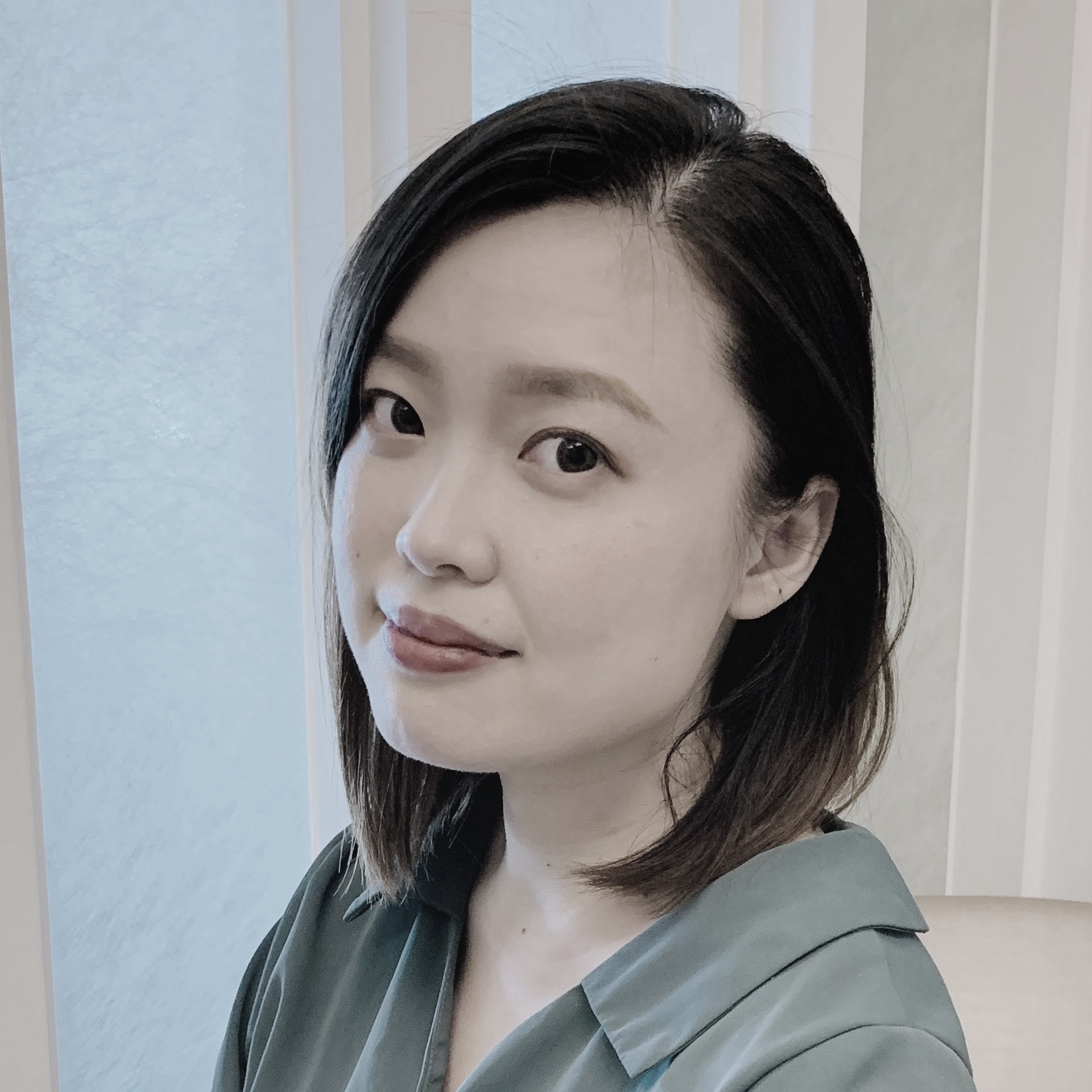黑白照片中，一名身穿條紋襯衫的女子正在微笑。
