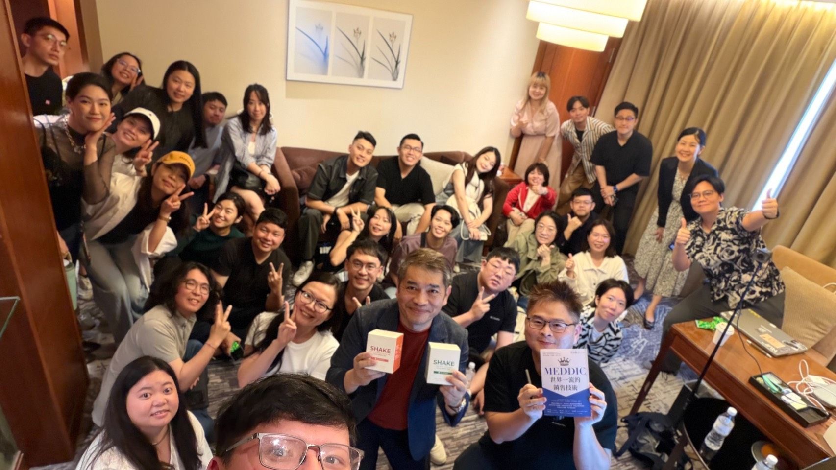 一群人坐在一張長桌旁,舉著牌子。