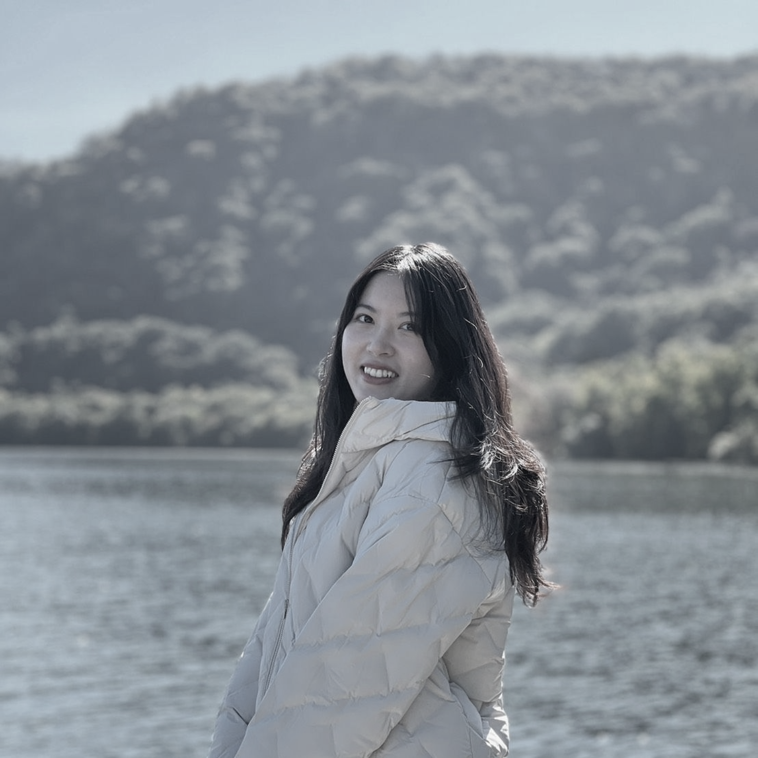 一張黑白照片，照片上是一位戴著掛繩、微笑的女人。
