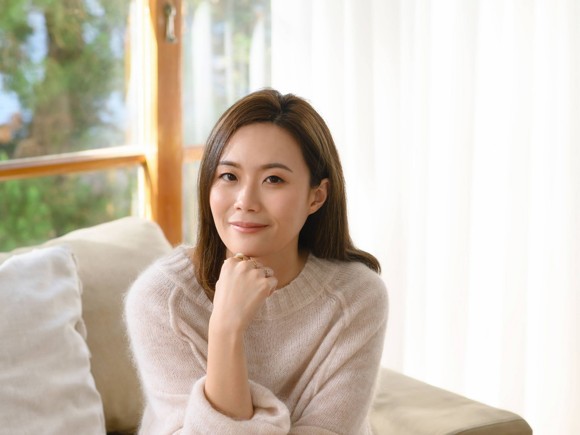 一位戴著墨鏡的女士坐在水體前的桌子旁