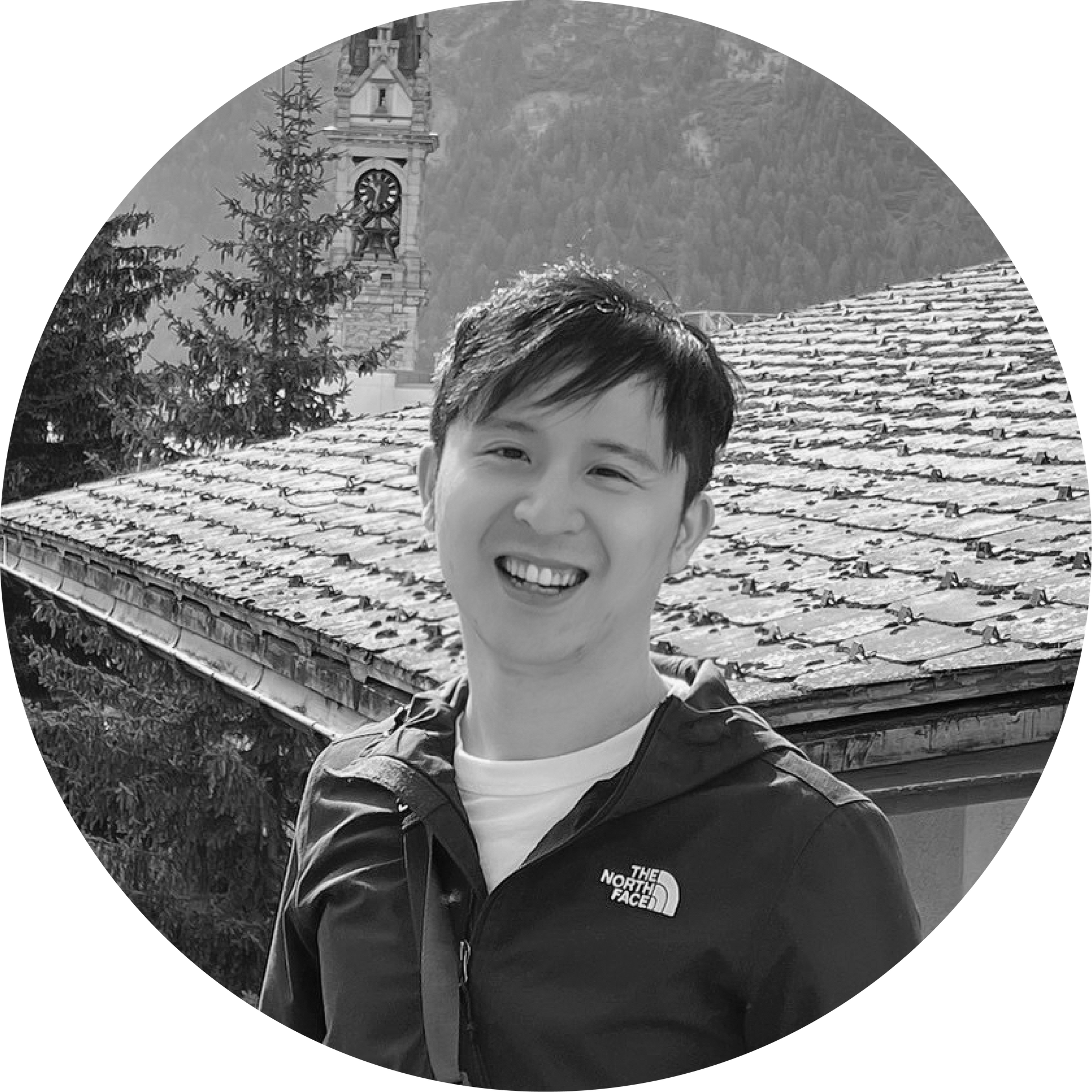 黑白照片中，一名穿著北臉夾克的男子微笑著
