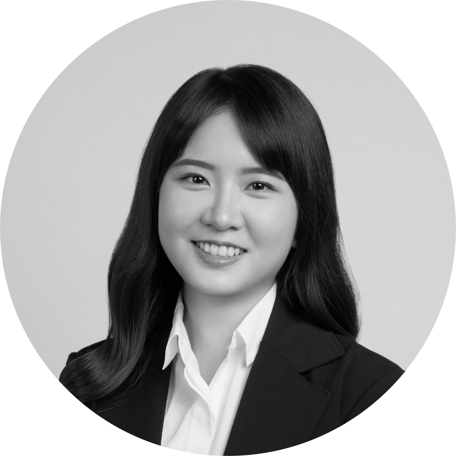 一張黑白照片中，一位穿著西裝和白襯衫的女人微笑著。