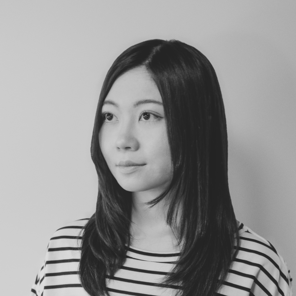 黑白照片中，一名身穿白色夾克的女子微笑著。