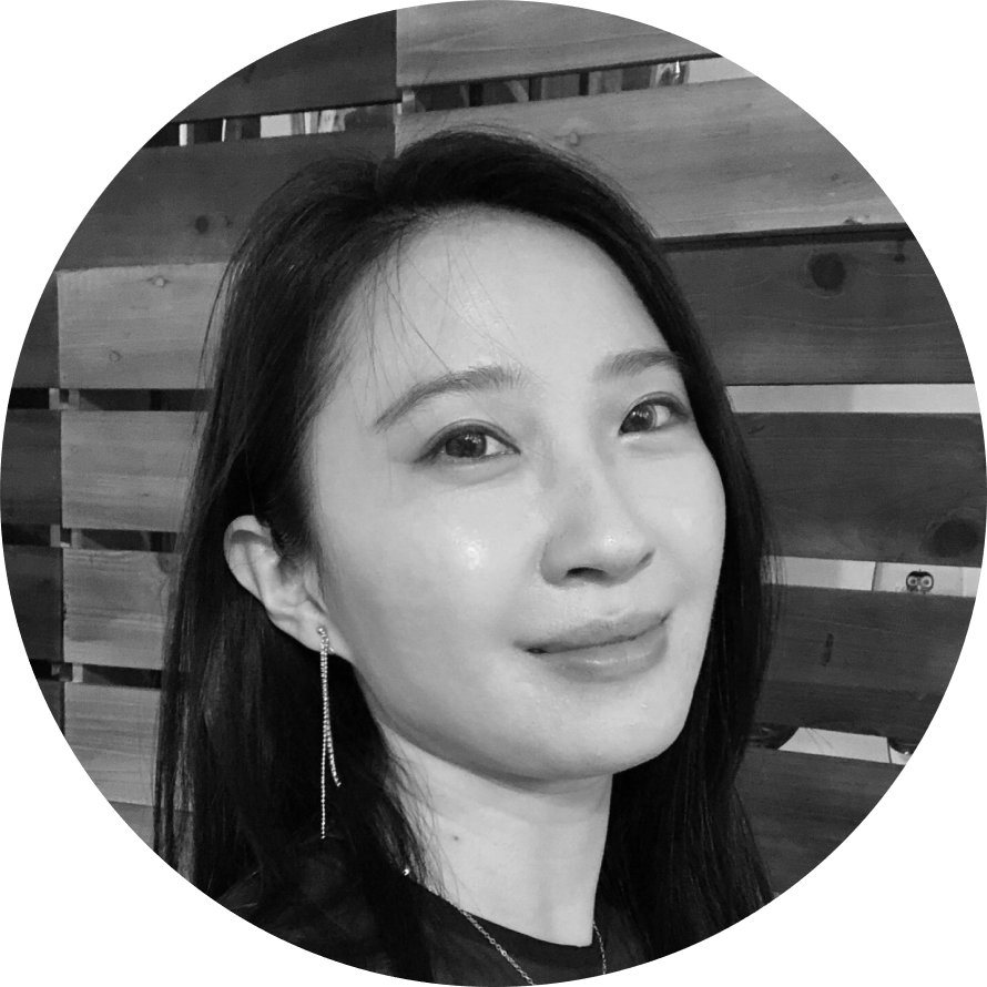 一張女人站在木柵欄前的黑白照片。