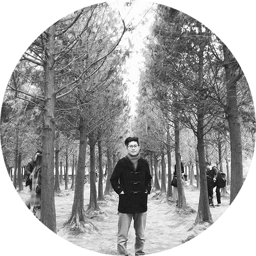 一張男人站在森林裡的黑白照片。