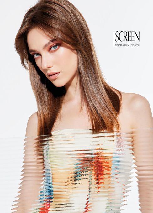 Ritratto di una donna con lunghi capelli castani, in posa su uno sfondo bianco con il logo “SCREEN”.