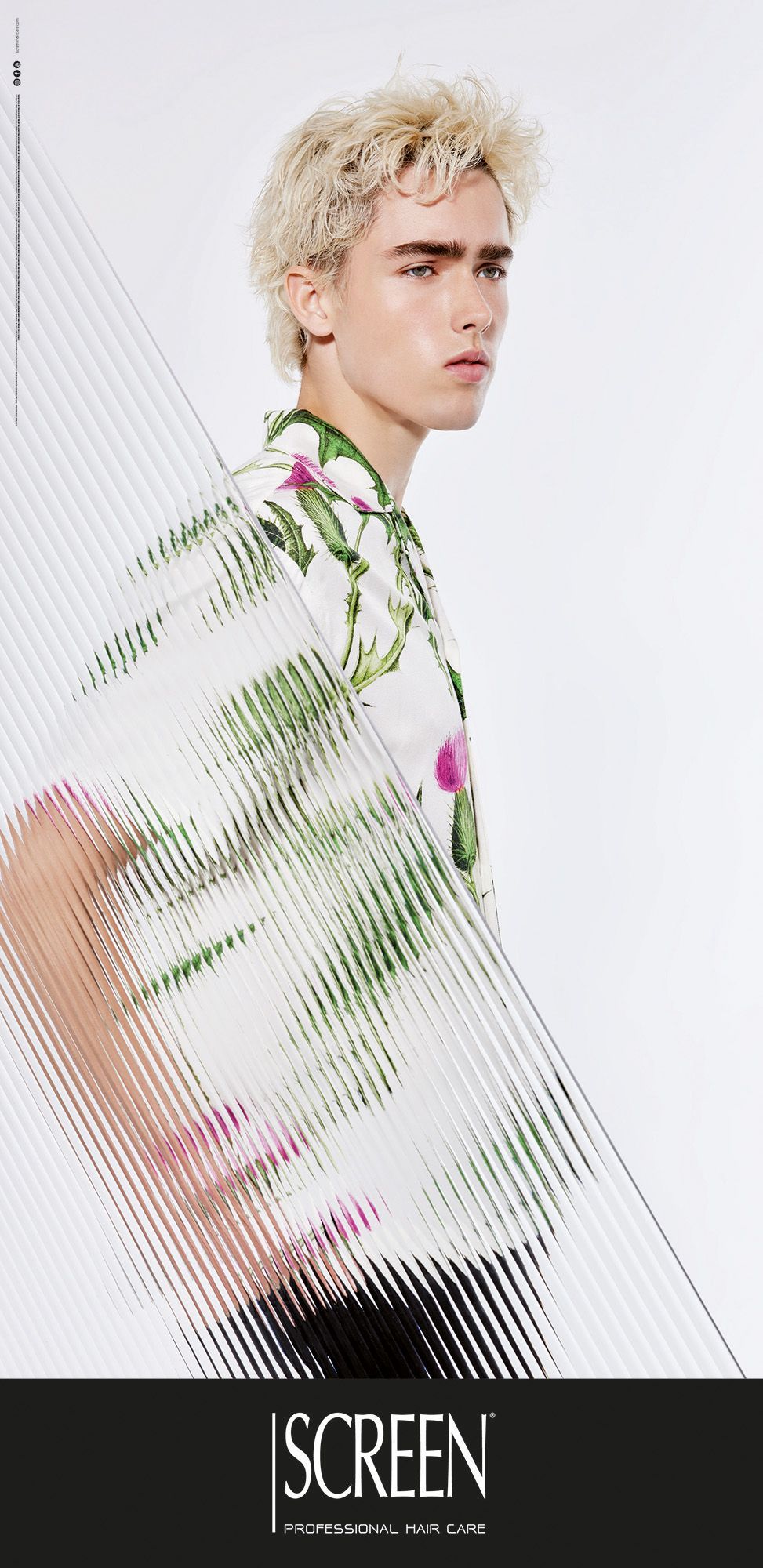 Modella con camicia bianca a fiori, in posa su sfondo bianco con effetto mosso.