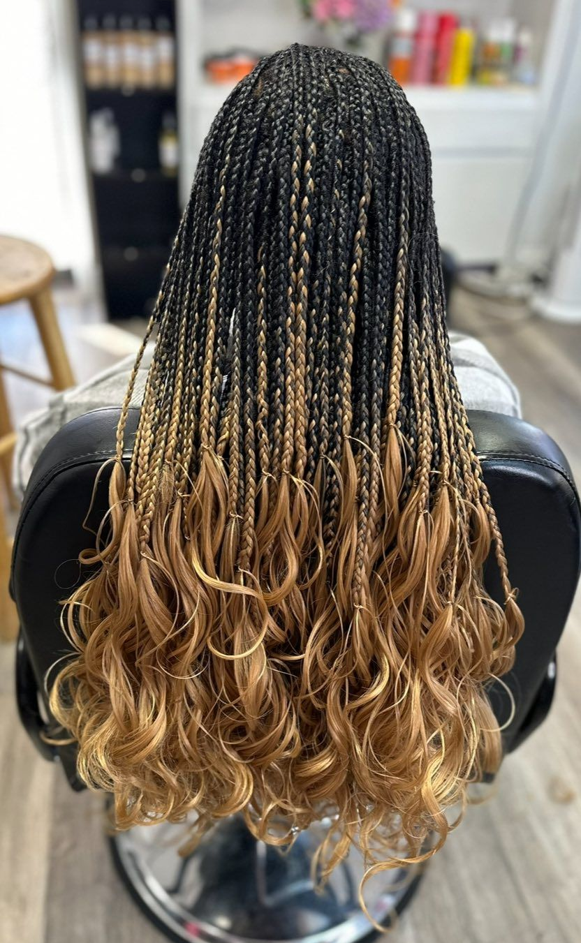Long black and blonde box braids with curly ends.